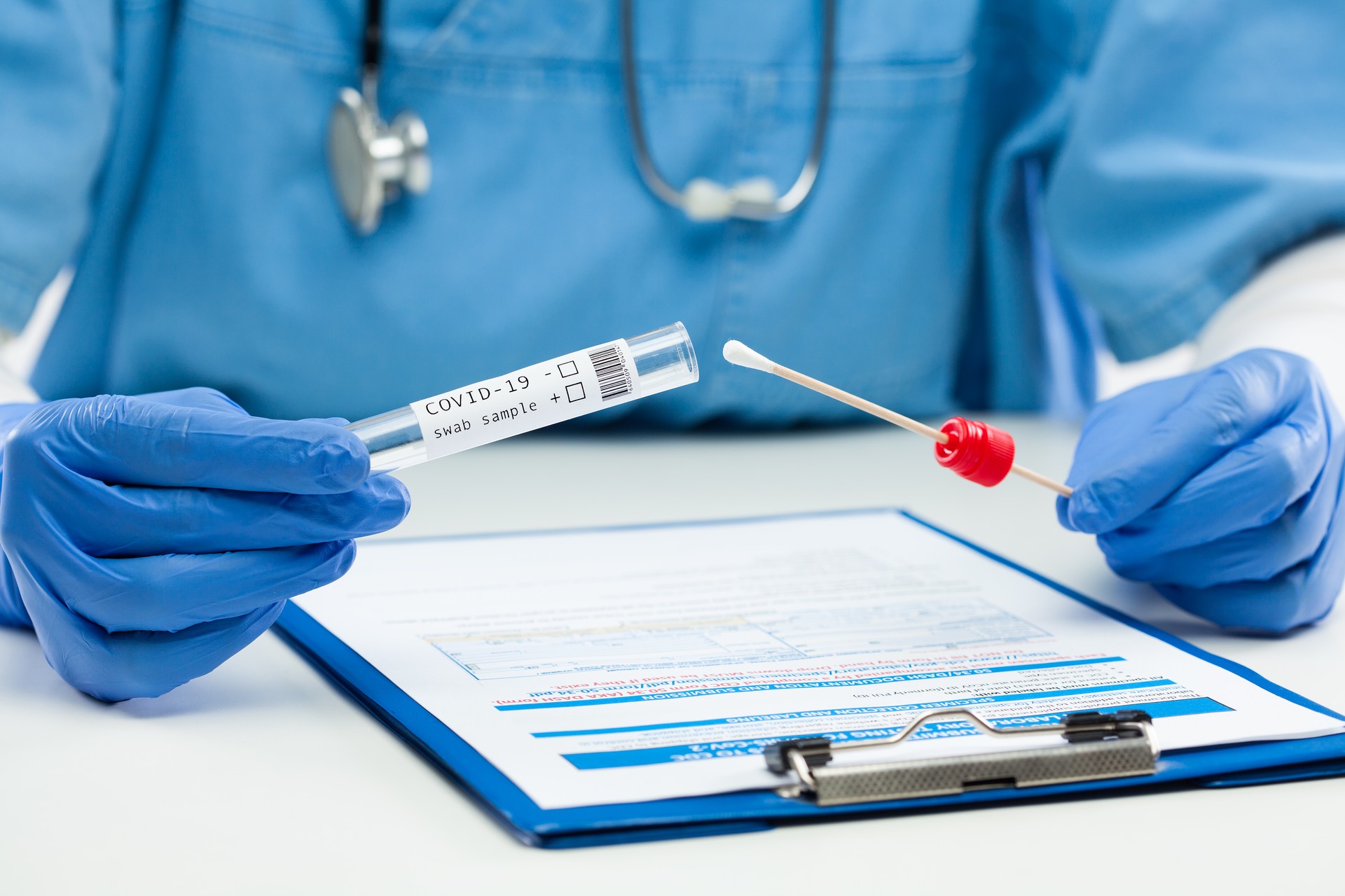 Medical worker GP doctor holding swab sample collection kit