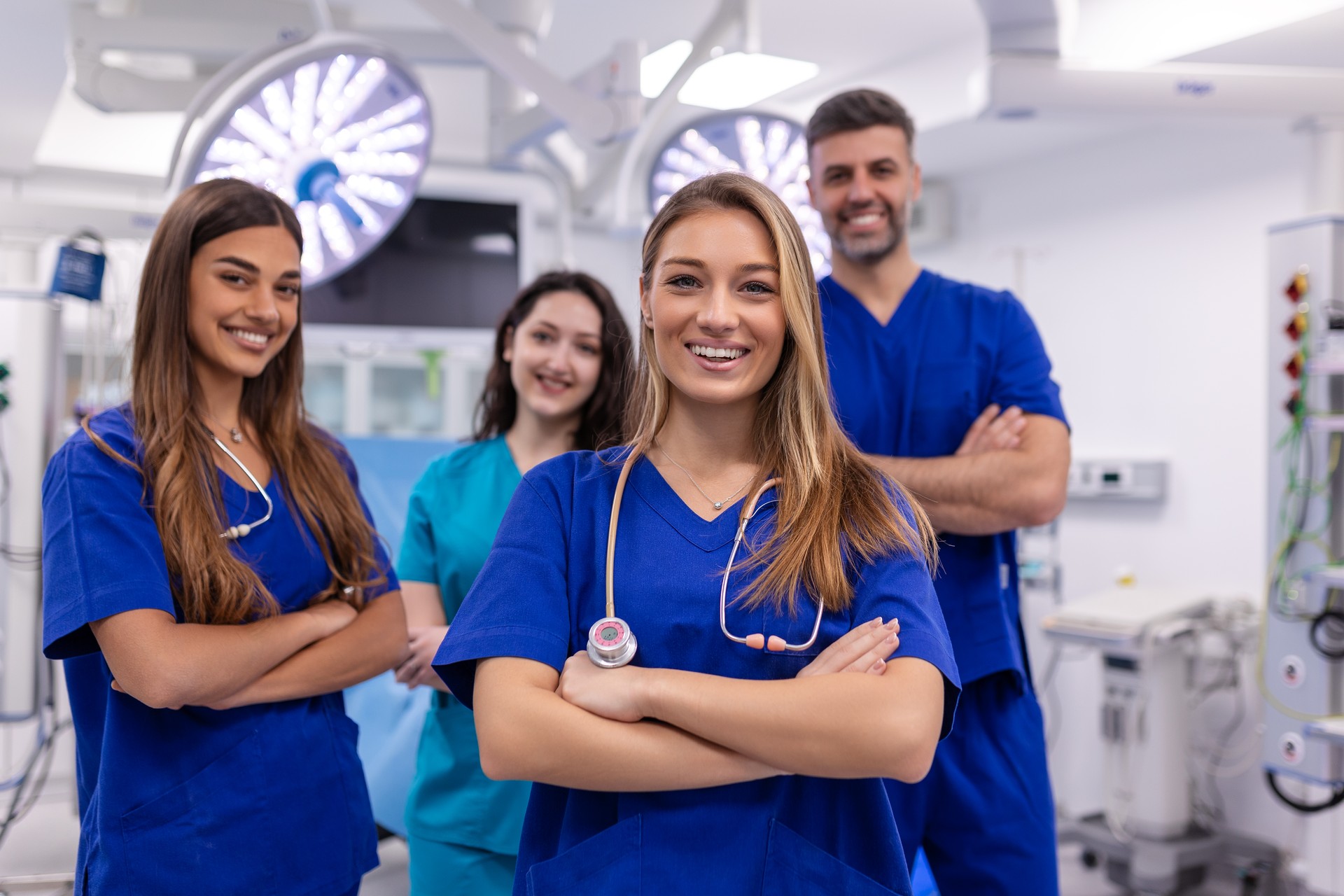 Closeup front view of group of mixed age doctors and nurses standing side by side and looking at the camera. Young female doctor is in the front.